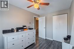 Bedroom with dark wood-style floors, a closet, a ceiling fan, and a textured ceiling - 