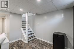 Stairway with a drop ceiling, wood finished floors, and recessed lighting - 