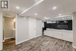 Living room featuring wood finished floors, a paneled ceiling, an AC wall unit, and recessed lighting - 