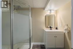 Bathroom featuring a shower stall, vanity, and dark wood-style flooring - 