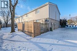 Snow covered property with brick siding and a wooden deck - 