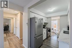 Kitchen featuring light countertops, stainless steel appliances, white cabinets, dark wood-style floors, and a textured ceiling - 