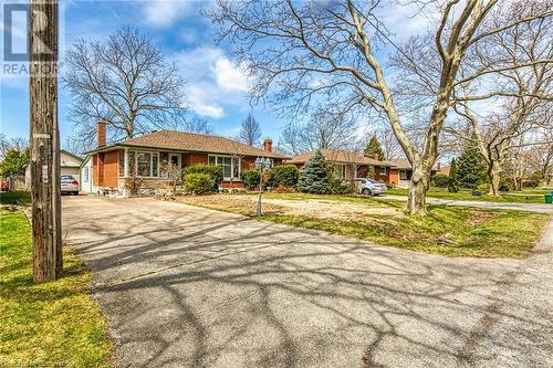 View of front of property with brick siding, aphalt driveway, a front lawn, and a chimney - 9 Gavin Drive, St. Catharines, ON - Outdoor