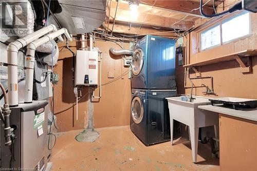 Clothes washing area featuring laundry area, tankless water heater, and stacked washer / drying machine - 9 Gavin Drive, St. Catharines, ON - Indoor Photo Showing Laundry Room