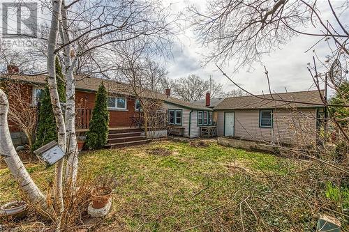 Rear view of property with a chimney and a lawn - 9 Gavin Drive, St. Catharines, ON - Outdoor