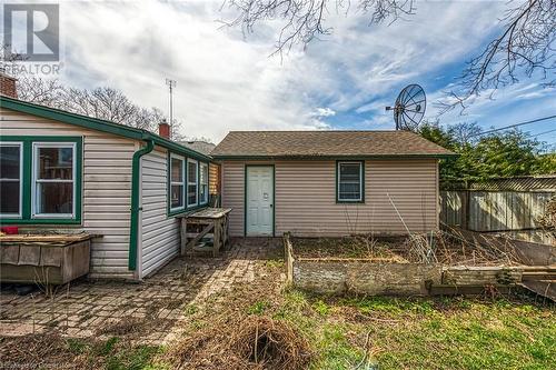 Rear view of house with a vegetable garden, fence, and a shingled roof - 9 Gavin Drive, St. Catharines, ON - Outdoor
