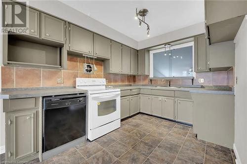 Kitchen with gray cabinets, white electric stove, decorative backsplash, dishwasher, and a sink - 9 Gavin Drive, St. Catharines, ON - Indoor Photo Showing Kitchen