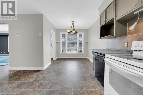 Kitchen featuring black dishwasher, white range with electric stovetop, baseboards, and an inviting chandelier - 9 Gavin Drive, St. Catharines, ON - Indoor Photo Showing Kitchen
