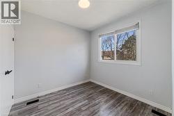 Second bedroom with large window and laminate flooring - 