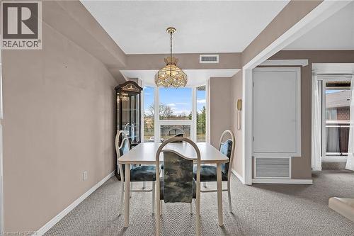 Carpeted dining room with baseboards, a chandelier, and visible vents - 416 Limeridge Road E Unit# 309, Hamilton, ON - Indoor