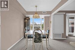 Carpeted dining room with baseboards, a chandelier, and visible vents - 