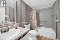 Bathroom featuring tile patterned floors, vanity, shower / bathtub combination with curtain, and toilet - 
