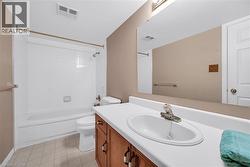 Bathroom featuring vanity, toilet, washtub / shower combination, and visible vents - 