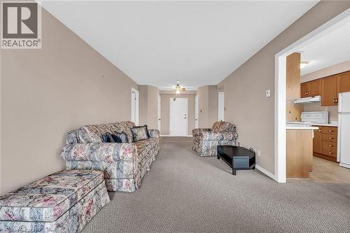 Living room featuring light carpet, baseboards, and a ceiling fan - 416 Limeridge Road E Unit# 309, Hamilton, ON - Indoor