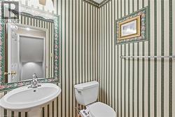 Bathroom with wallpapered walls and a sink - 