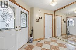 Entryway with inlaid floor details and light tile patterned flooring - 