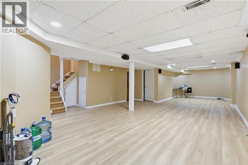 Finished basement with light wood-type flooring, stairway, and a paneled ceiling - 3372 Bobwhite Mews, Mississauga, ON 