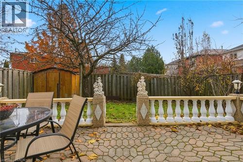 Fenced backyard featuring outdoor dining area, a patio, and a storage unit - 3372 Bobwhite Mews, Mississauga, ON 