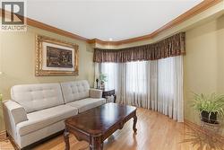 Living room featuring wood-type flooring and crown molding - 