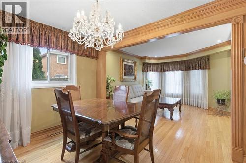 Dining space featuring light wood-type flooring, ornamental molding, and a chandelier - 3372 Bobwhite Mews, Mississauga, ON 