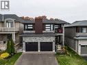 View of front of home featuring stone siding, asphalt driveway, a balcony, and a garage - 4040 Stadelbauer Drive, Beamsville, ON  - Outdoor With Facade 