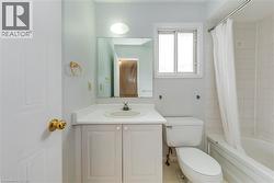 Bathroom featuring vanity, shower / bath combo with shower curtain, and tile patterned floors - 