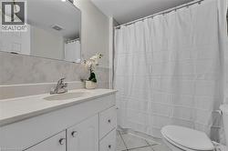 Bathroom featuring tile walls, tile patterned flooring, vanity, and curtained shower - 