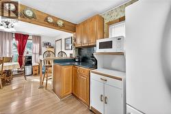 Kitchen featuring healthy amount of natural light, white appliances, a kitchen breakfast bar, and decorative backsplash - 