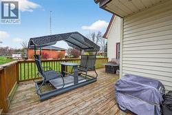 Wooden deck featuring grilling area and a yard - 