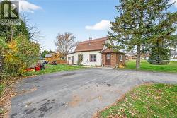 Dutch colonial with a gambrel roof, a front yard, a shingled roof, and brick siding - 