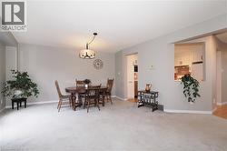 Dining room with light carpet and swagged chandelier - 