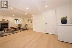 Recreation room with a fireplace, recessed lighting, and light wood-style luxury-vinyl-plank floors - 