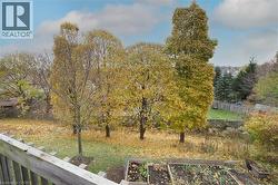 View of yard featuring mature trees and a vegetable garden - 