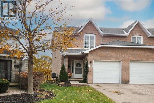 View of front of home featuring brick siding, shingled roof, front lawn, and single car garage - 511 Oakvale Drive Unit# 1, Waterloo, ON - Outdoor With Facade