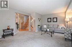 View of living room from the dining room with stairwells in the background - 