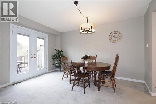 Dining room with swagged chandelier and French doors leading to outdoor wooden deck - 511 Oakvale Drive Unit# 1, Waterloo, ON - Indoor Photo Showing Dining Room