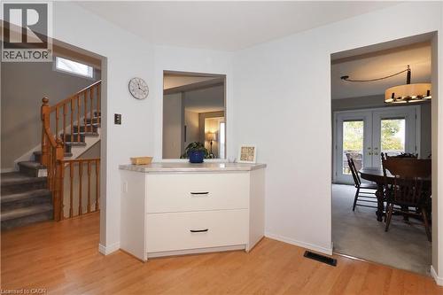 Kitchen view of island style white cabinet, stairway to second floor, light wood finished floors, and dining room - 511 Oakvale Drive Unit# 1, Waterloo, ON - Indoor Photo Showing Other Room