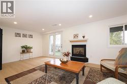 Brand new bright, spacious open concept recreation room with luxury-vinyl-plank flooring, a gas fireplace, and recessed lighting - 