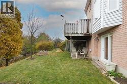 View of grassy yard with a patio area and wood deck - 