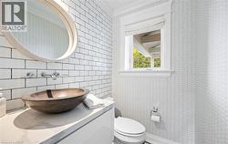 Half bath featuring vanity, crown molding, and tile walls - 