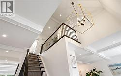 Stairway with recessed lighting, beamed ceiling, a chandelier, ornamental molding, and coffered ceiling - 