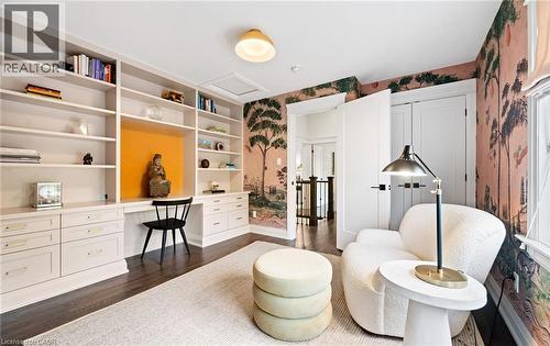 Sitting room featuring wallpapered walls, dark wood-style flooring, attic access, and built in study area - 735 George Street, Burlington, ON - Indoor