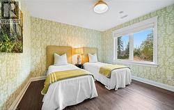 Bedroom with wallpapered walls and wood finished floors - 