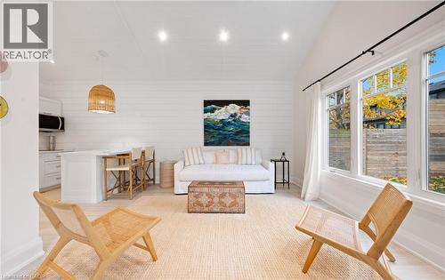 Living room featuring wooden walls, recessed lighting, light wood-style floors, and high vaulted ceiling - 735 George Street, Burlington, ON - Indoor