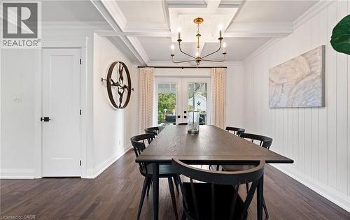Dining area with french doors, a chandelier, beam ceiling, dark wood finished floors, and coffered ceiling - 735 George Street, Burlington, ON - Indoor Photo Showing Dining Room