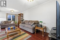 Living area with dark wood-style floors and baseboards - 