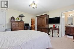 Bedroom with connected bathroom and light colored carpet - 