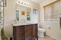 Full bath with curtained shower, vanity, and light tile patterned floors - 