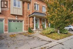 View of front of house with brick siding, a garage, asphalt driveway, and covered porch - 