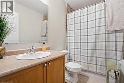 Full bathroom featuring a shower with curtain, vanity, and light tile patterned flooring - 